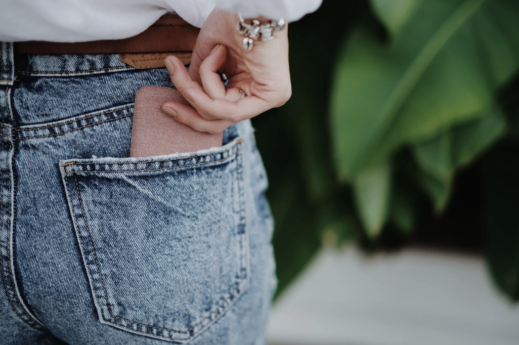 woman putting phone in back pocket
